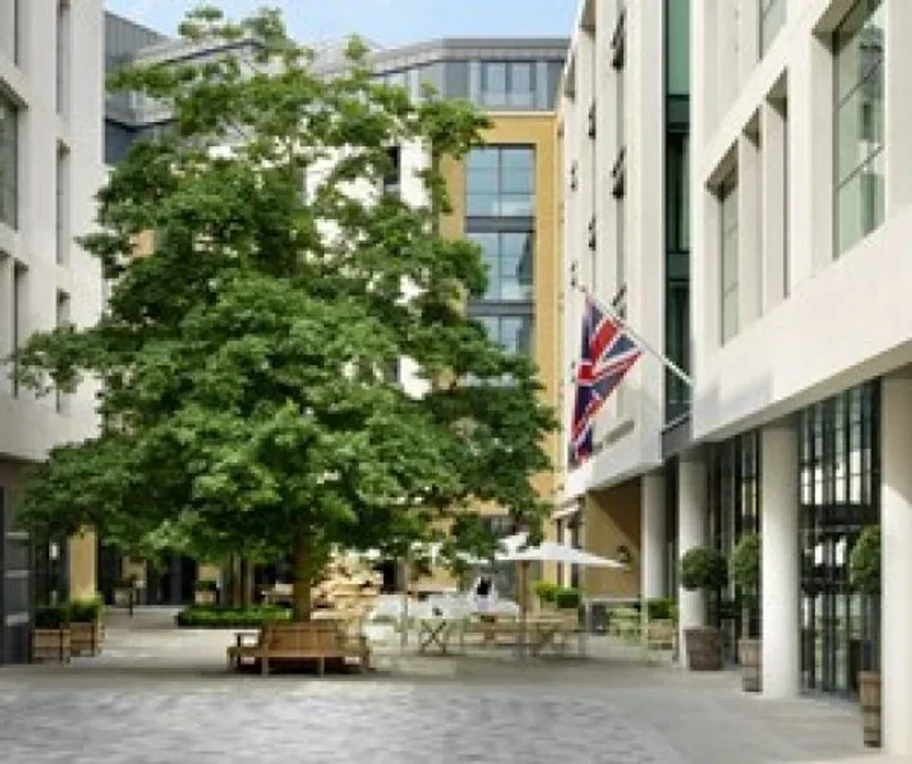 a photograph of a large building with a flag on it